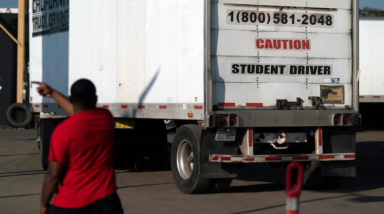 FILE - A student driver helps his classmate steer the wheel into the right direction as they practice driving in reverse in Calif., Nov. 17, 2021. (AP Photo/Jae C. Hong, File)