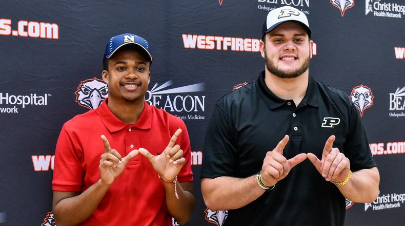 Lakota West’s Dylan Jones (left) and Steven Faucheux pose with their “W” signs during an early National Signing Day ceremony Wednesday afternoon at West. Jones is headed to the United States Naval Academy, while Faucheux is going to Purdue University. NICK GRAHAM/STAFF