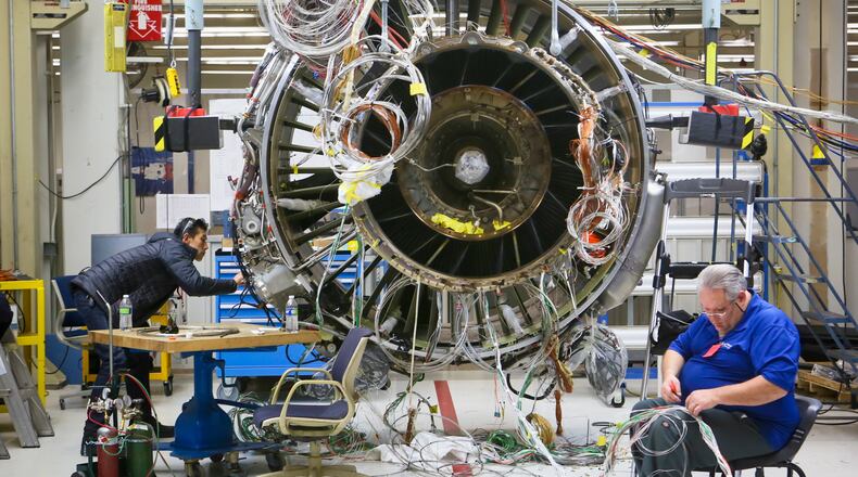 Engineers work on a LEAP commercial jet test engine at GE Aviation in Evendale, Friday, Dec. 19, 2014. The engine, made by CFM, a joint venture between GE and French manufacturer Snecma, will be more fuel efficient and contain advanced materials. GREG LYNCH / STAFF