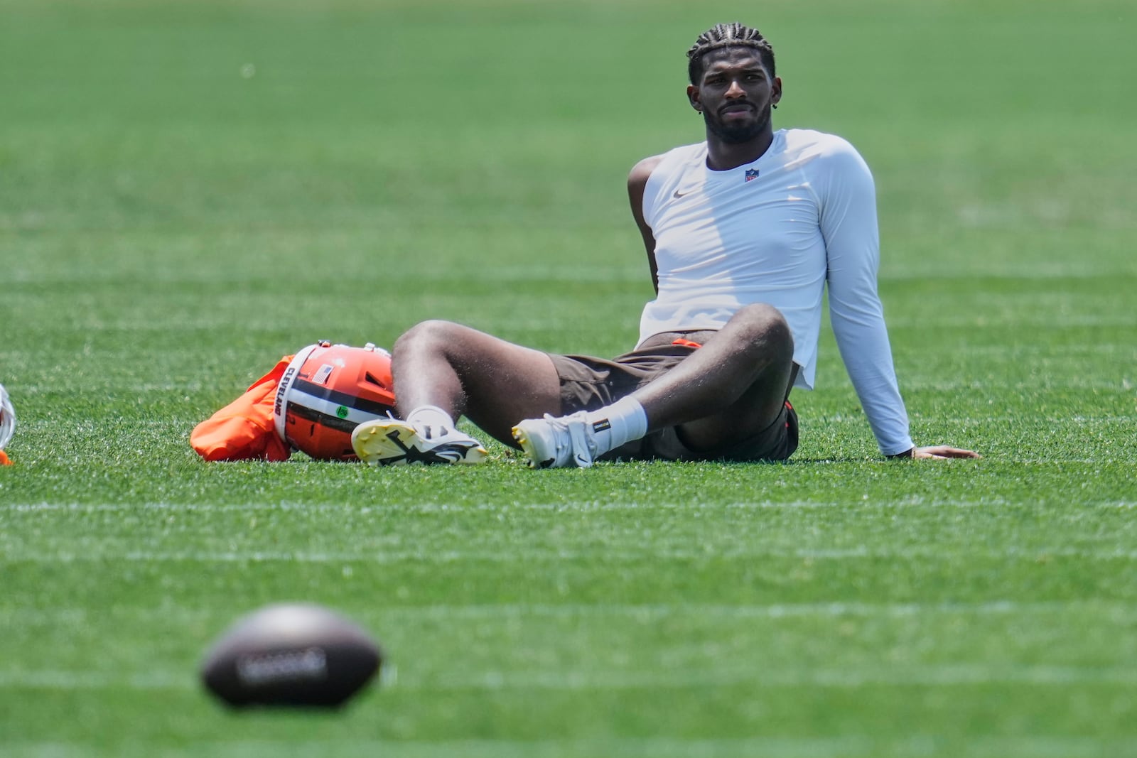 Cleveland Browns quarterback Shedeur Sanders (12) sits on the field after practice at NFL football minicamp in Berea, Ohio, Wednesday, June 11, 2025. (AP Photo/Sue Ogrocki)