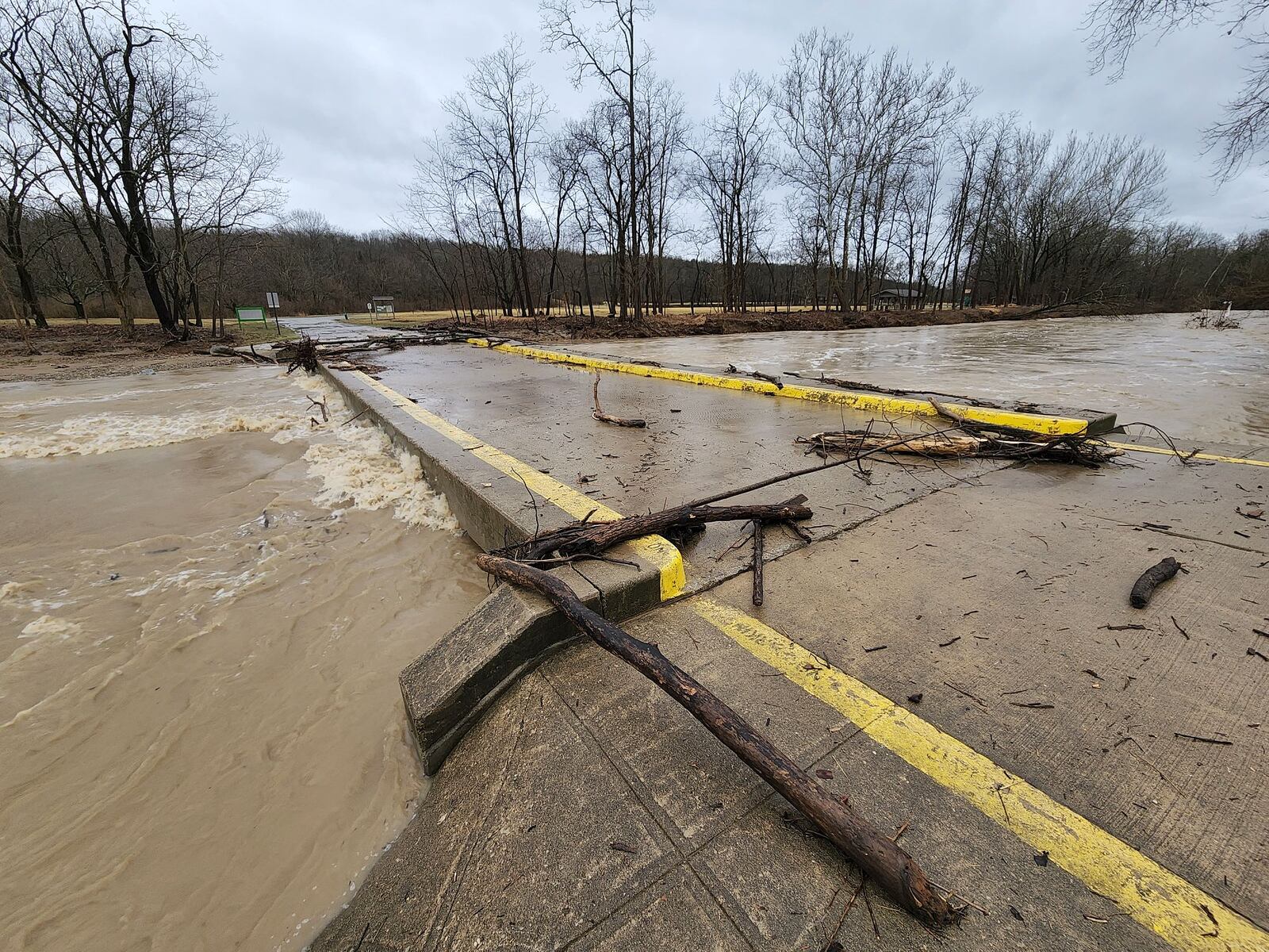 Overnight rain caused water and logs from Elk Creek to wash over the bridge making it impassable at Elk Creek MetroPark Sebald Park Area in Madison Township. NICK GRAHAM/STAFF