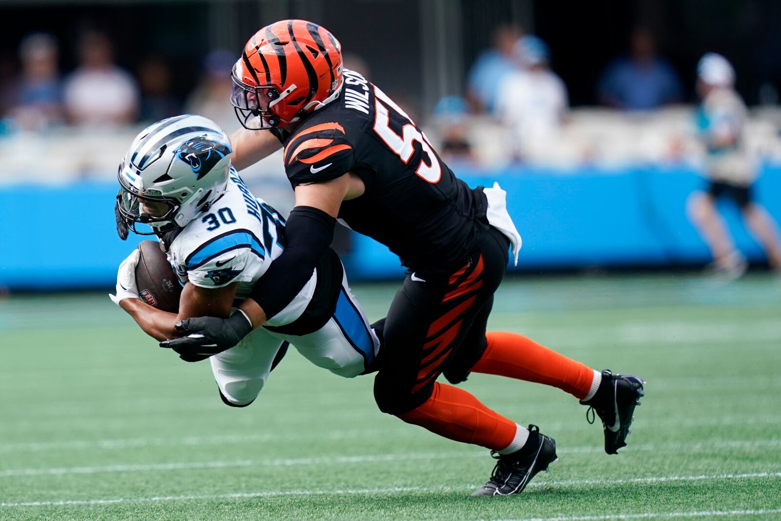 Carolina Panthers running back Chuba Hubbard is tackled by Cincinnati Bengals linebacker Logan Wilson during the second half of an NFL football game, Sunday, Sept. 29, 2024, in Charlotte, N.C. (AP Photo/Erik Verduzco)