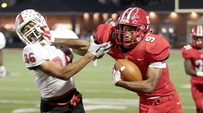 Fairfield’s JuTahn McClain (9) stiff-arms Colerain’s Deshawn Pace on a run during a game at Fairfield Stadium on Oct. 13, 2017.