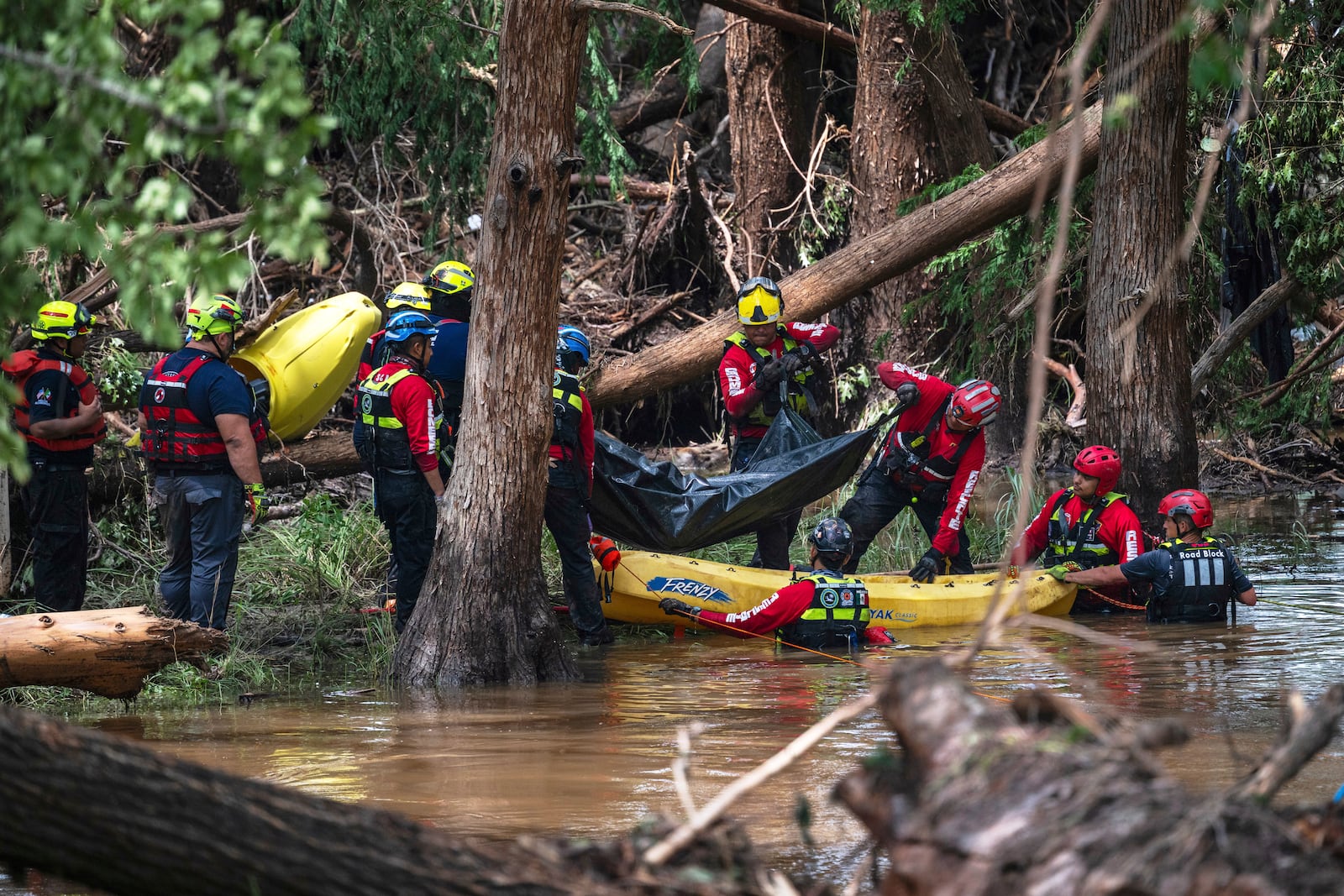 FILE - Firefighters from Ciudad Acuña, Mexico, load a body into a raft as they prepare for a water recovery along the Guadalupe River days after a flash flood swept through the area July 7, 2025, in Ingram, Texas. (AP Photo/Eli Hartman, File)