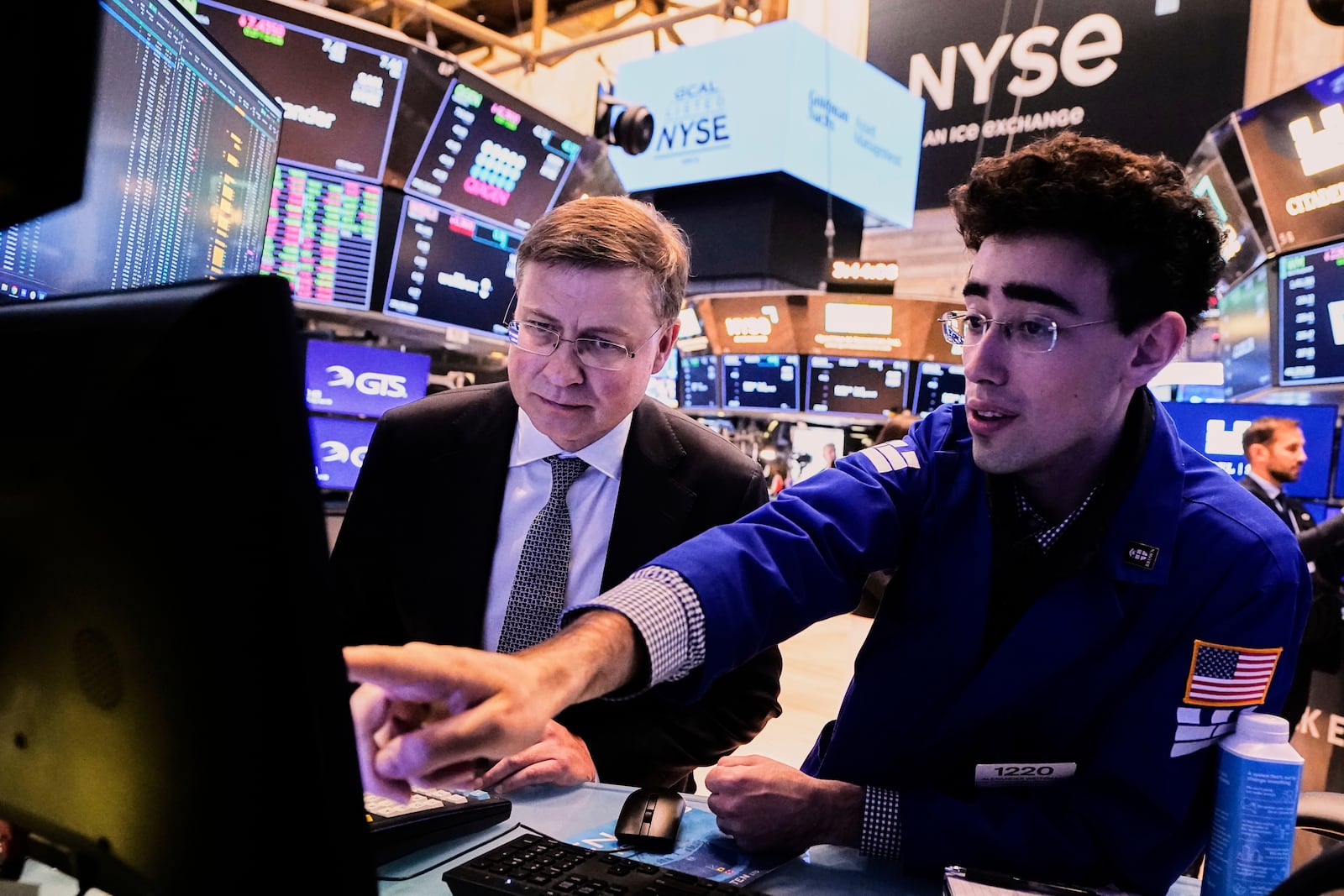 Valdis Dombrovskis, left, Executive Vice President of the European Commission for Economy and Productivity, meets with Specialist Alexander Weitzman on the floor of the New York Stock Exchange, Monday, April 28, 2025. (AP Photo/Richard Drew)
