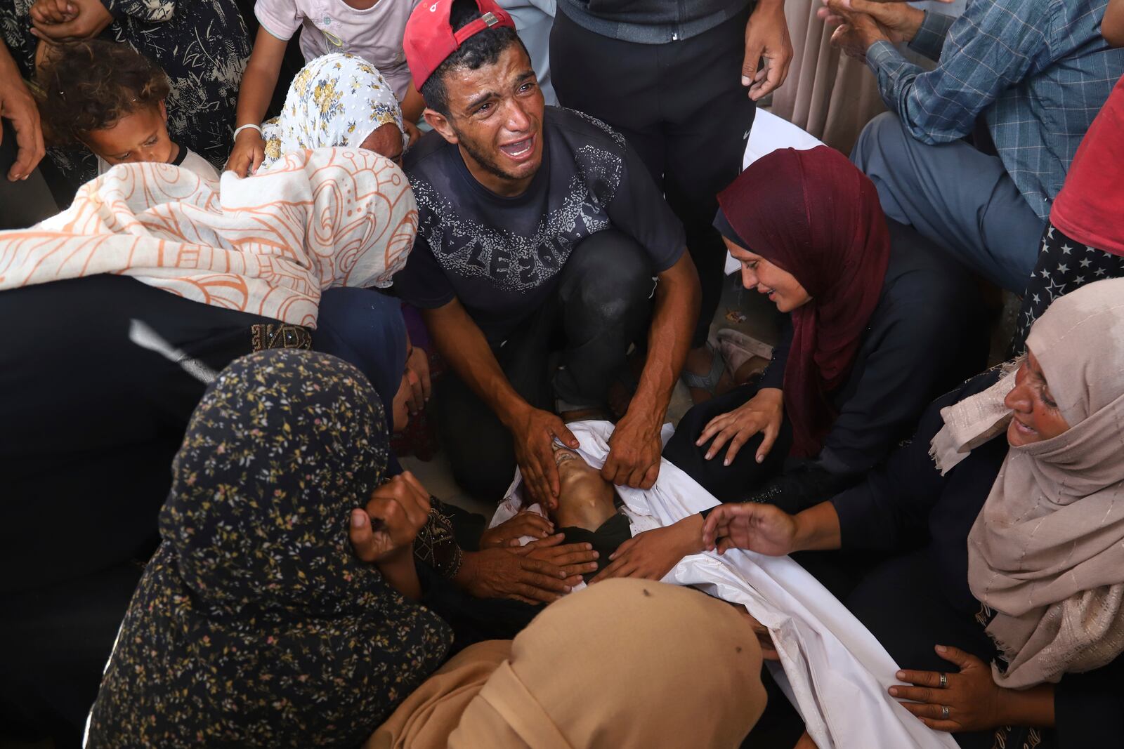 Palestinian relatives mourn over the body of a man killed in an Israeli strike, at Nasser Hospital in Khan Younis, southern Gaza Strip, Tuesday, June 17, 2025. (AP Photo/Mariam Dagga)