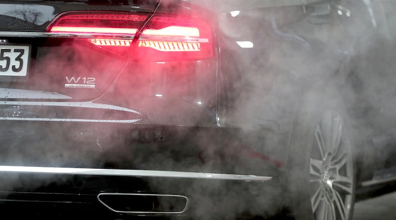 FILE - A luxury Audi car is surrounded by exhaust gases as it is parked with a running engine in front of the Chancellery in Berlin, Germany, Wednesday, Nov. 20, 2019. (AP Photo/Michael Sohn, File)