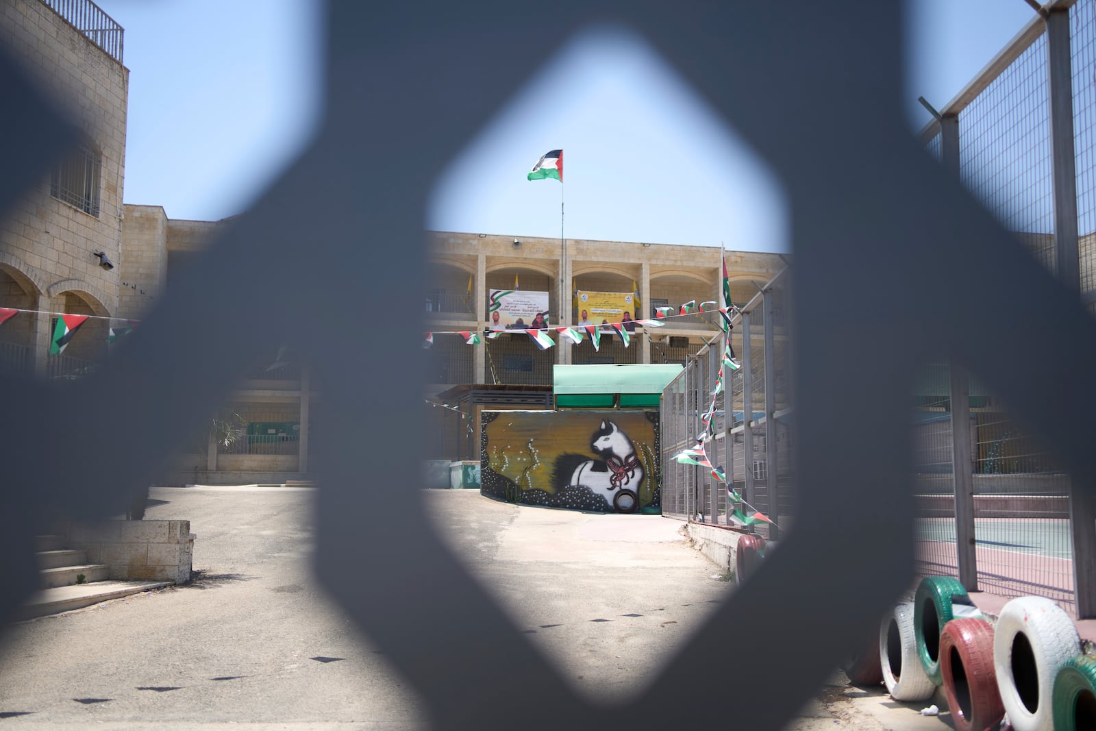 Memorial banners for Palestinian-American Sayfollah Musallet and Mohammed al-Shalabi, both killed by Israeli settlers, are displayed at a school in the West Bank town of Al Mazra as-Sharqiya, Monday, July 21, 2025. (AP Photo/Maya Alleruzzo)