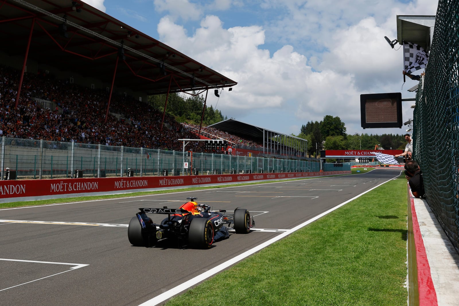 The checkered flag goes out as Red Bull driver Max Verstappen of the Netherlands crosses the finish line to take first place during the sprint race ahead of the Formula One Grand Prix at the Spa-Francorchamps racetrack in Spa, Belgium, Saturday, July 26, 2025. (Stephanie Lecocq, Pool Photo via AP)
