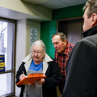 Jim Fescina, right, with AxOhioTax, gets signatures from Rob and Belinda Batdorf as they go in to pay taxes Thursday, Feb. 26, 2026 at Butler County Government Services Center building on High Street in Hamilton. AxOhioTax was collecting signatures in order to put property tax repeal on the November ballot. NICK GRAHAM/STAFF