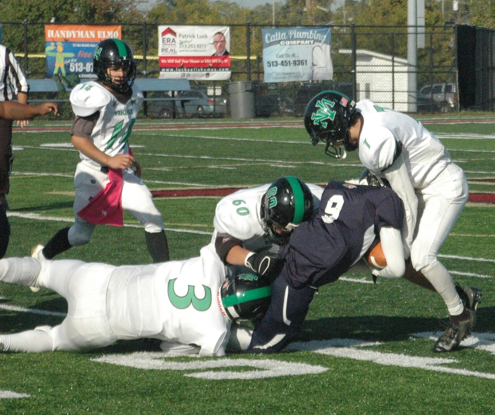 New Miami’s Danny Spivey (3), Erik Tatman (60) and Jordan Robinette (7) bring down Dannie Leary of Cincinnati College Prep Academy on Oct. 13 at Western Hills’ McCartney Stadium. New Miami won 36-8. RICK CASSANO/STAFF