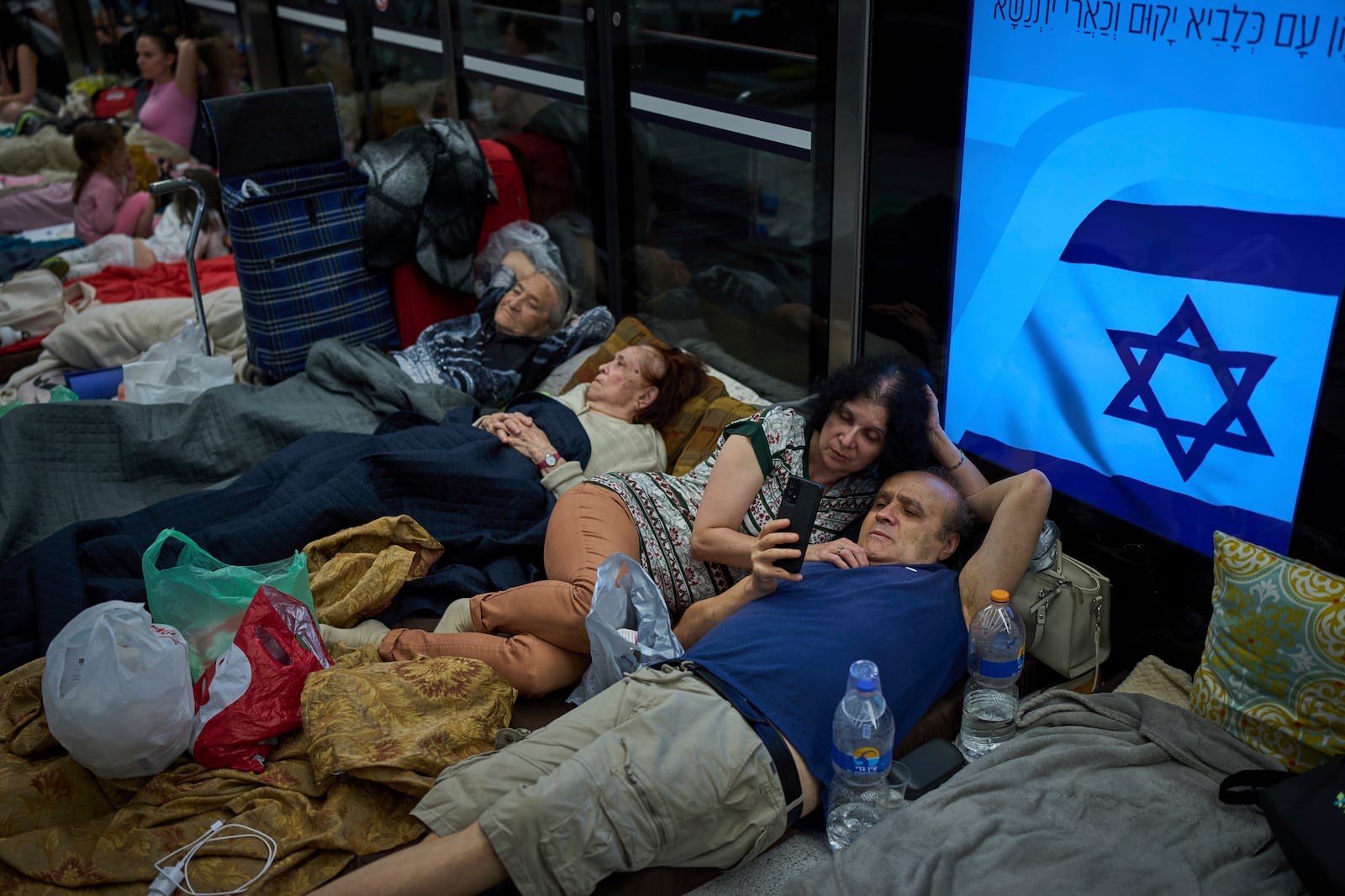 People take shelter in an underground metro station as a precaution against possible Iran missile attacks, in Ramat Gan, near Tel Aviv, Israel, Tuesday, June 17, 2025. (AP Photo/Oded Balilty)