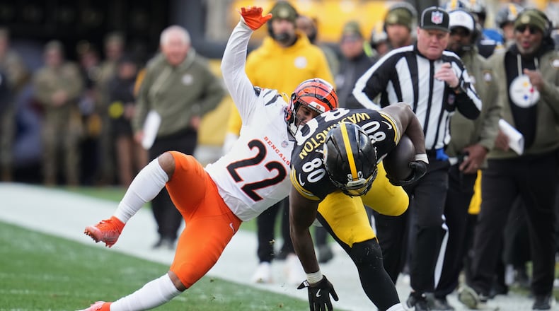 Pittsburgh Steelers tight end Darnell Washington (80) avoids a tackle by Cincinnati Bengals safety Geno Stone (22) during the first half of an NFL football game Sunday, Nov. 16, 2025, in Pittsburgh. (AP Photo/Gene J. Puskar)
