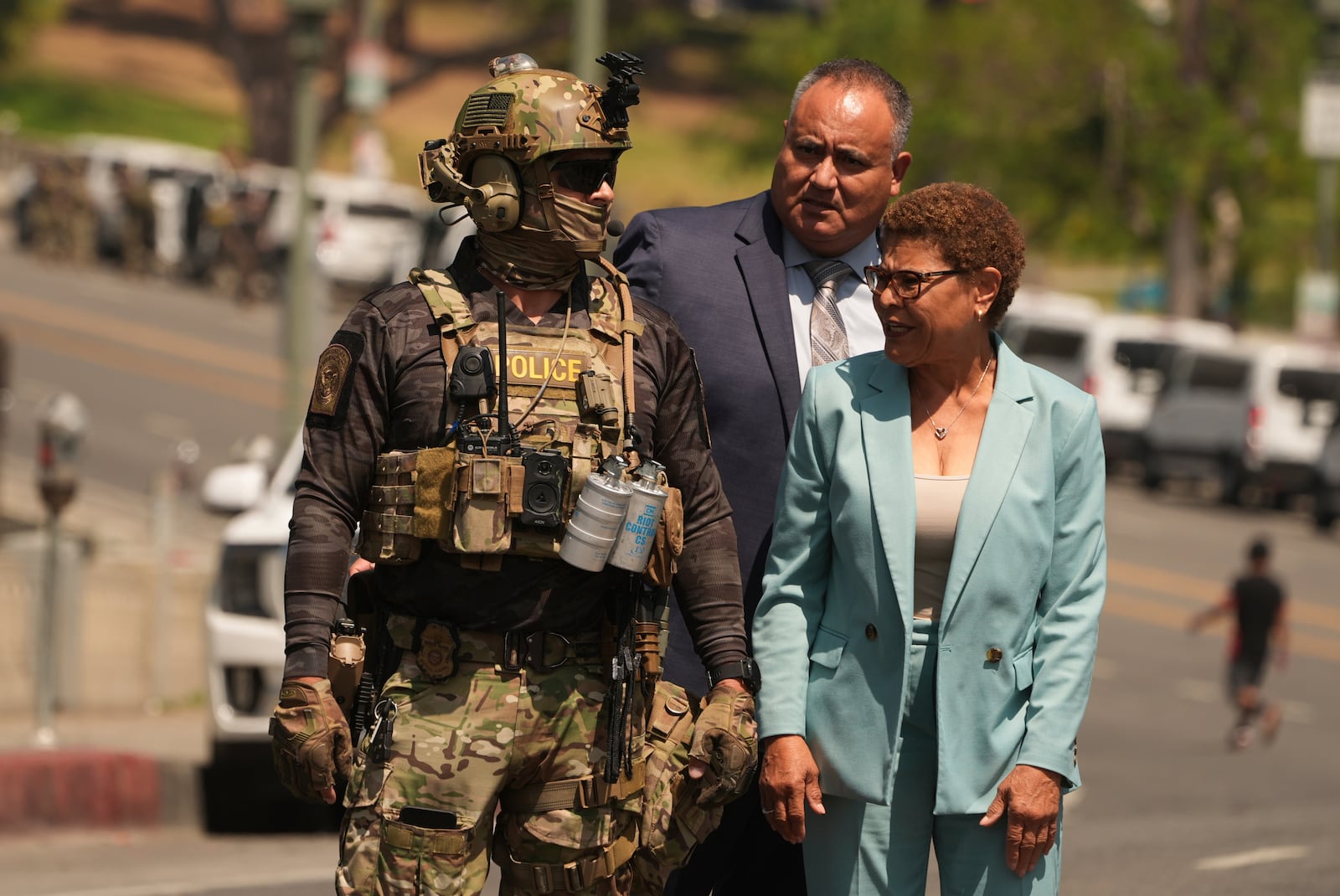 Los Angeles Mayor Karen Bass walks with a federal agent at MacArthur Park Monday, July 7, 2025, in Los Angeles. (AP Photo/Damian Dovarganes)
