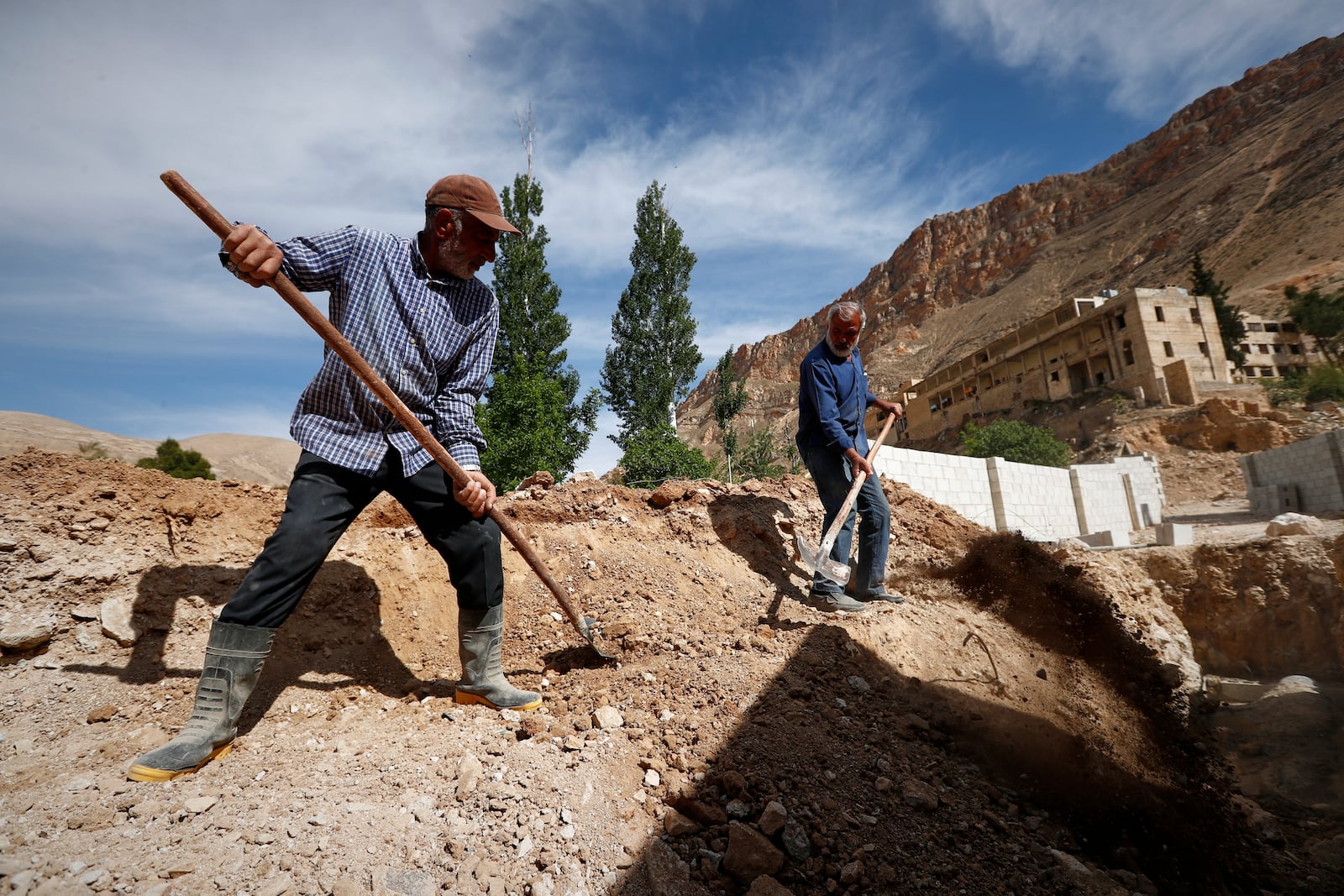 Residents work on rebuilding their properties damaged during the war in Ein el-Fijeh, Barada Valley, Syria, Thursday, May 8, 2025. (AP Photo/Omar Sanadiki)