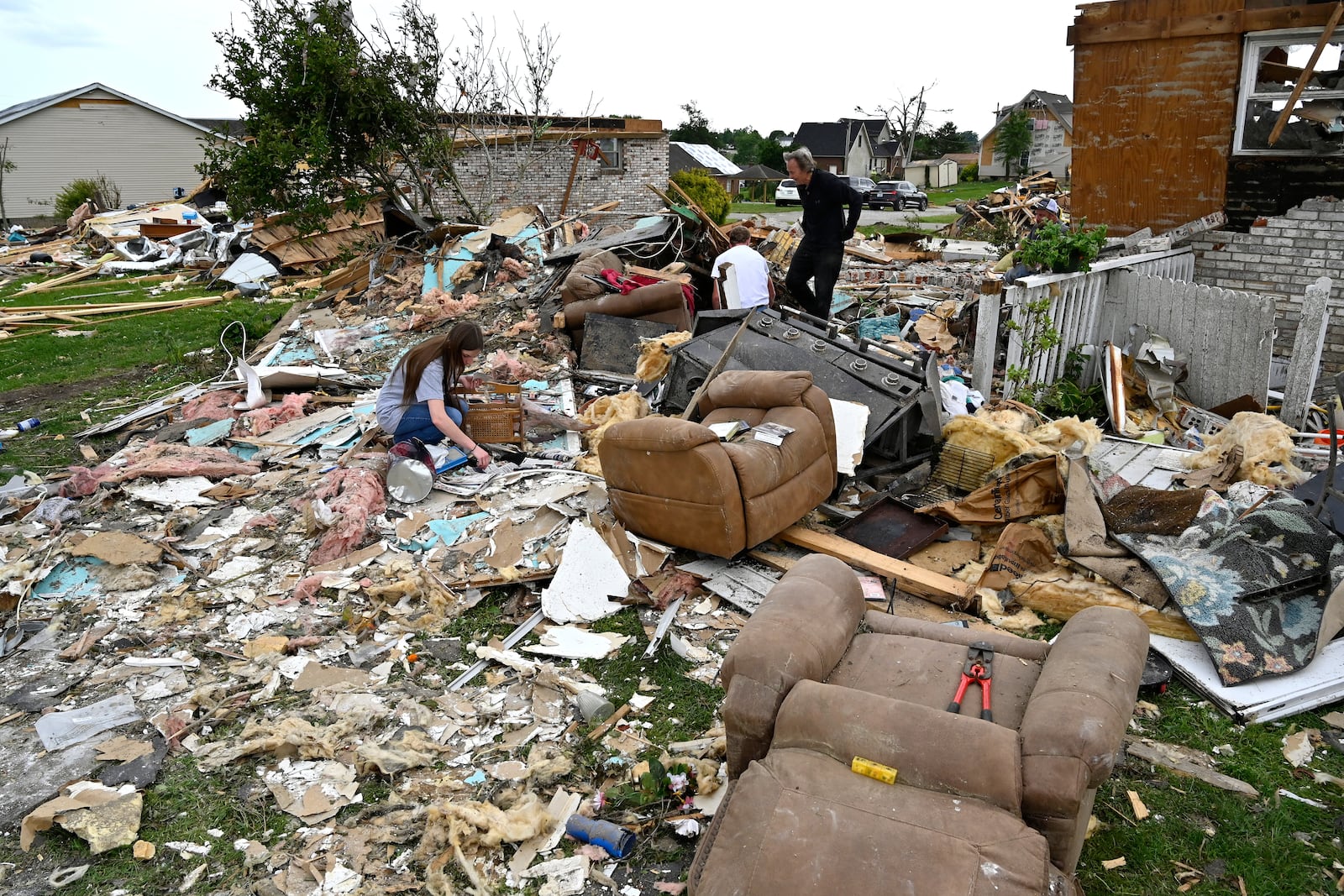 Volunteers help go through the remains of a home looking for what they could salvage in the Sunshine Hills neighborhood in London, Ky., Monday, May 19, 2025. (AP Photo/Timothy D. Easley)
