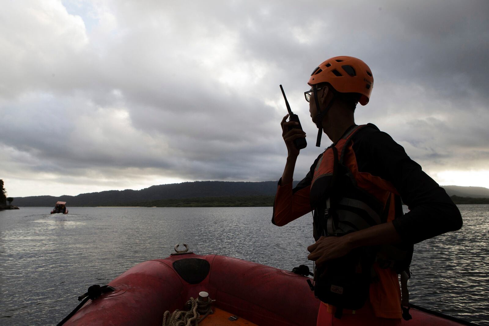 A member of the National Search and Rescue Agency (BASARNAS) talks on his radio during a search search for the victims of a sunken ferry in the waters off Jembrana, Bali, Indonesia, Friday, July 4, 2025. (AP Photo/Firdia Lisnawati)