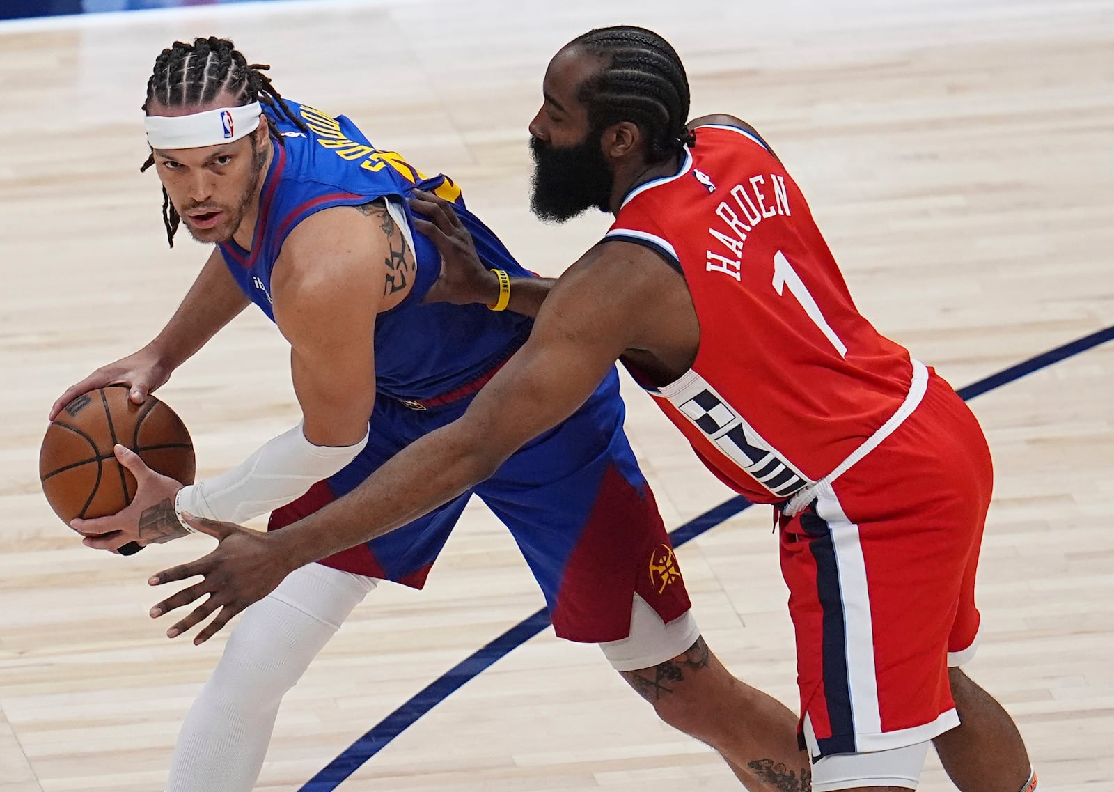 Denver Nuggets forward Aaron Gordon, left, looks to pass the ball as Los Angeles Clippers guard James Harden, right, defends in the first half of Game 1 of an NBA first-round playoff series Saturday, April 19, 2025, in Denver. (AP Photo/David Zalubowski)