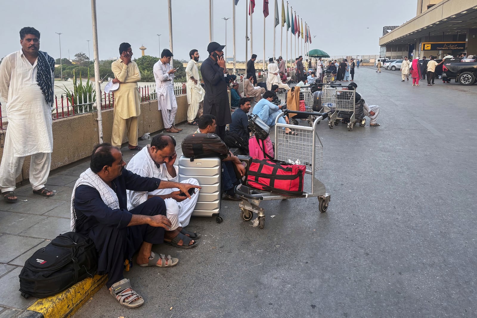 Stranded passengers wait at a arrival area of Jinnah airport, which shutdown following Indian airstrikes in Pakistani areas, in Karachi, Pakistan, Wednesday, May 7, 2025. (AP Photo/Mohammad Farooq)