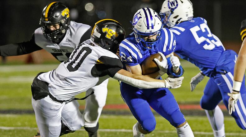 Wyoming's Joel Hancock is tackled by Shawnee's Hayden Coppess during Friday's playoff game. BILL LACKEY/STAFF
