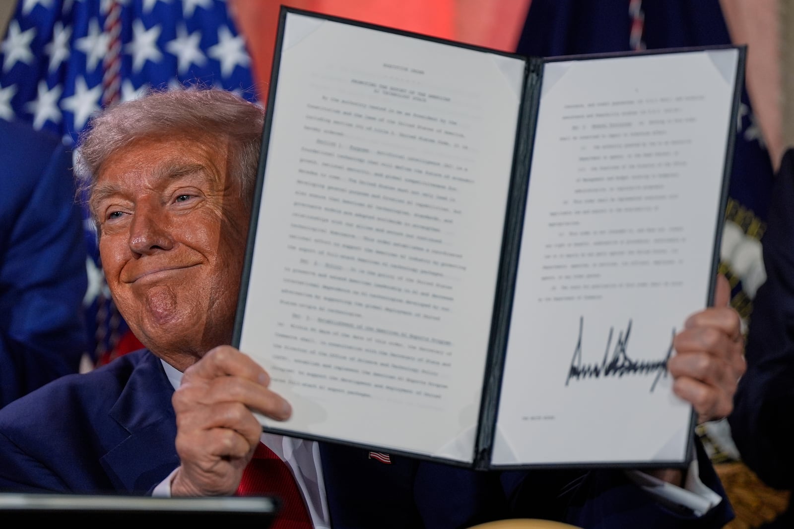 President Donald Trump holds a signed executive order after speaking during an AI summit at the Andrew W. Mellon Auditorium, Wednesday, July 23, 2025, in Washington. (AP Photo/Julia Demaree Nikhinson)