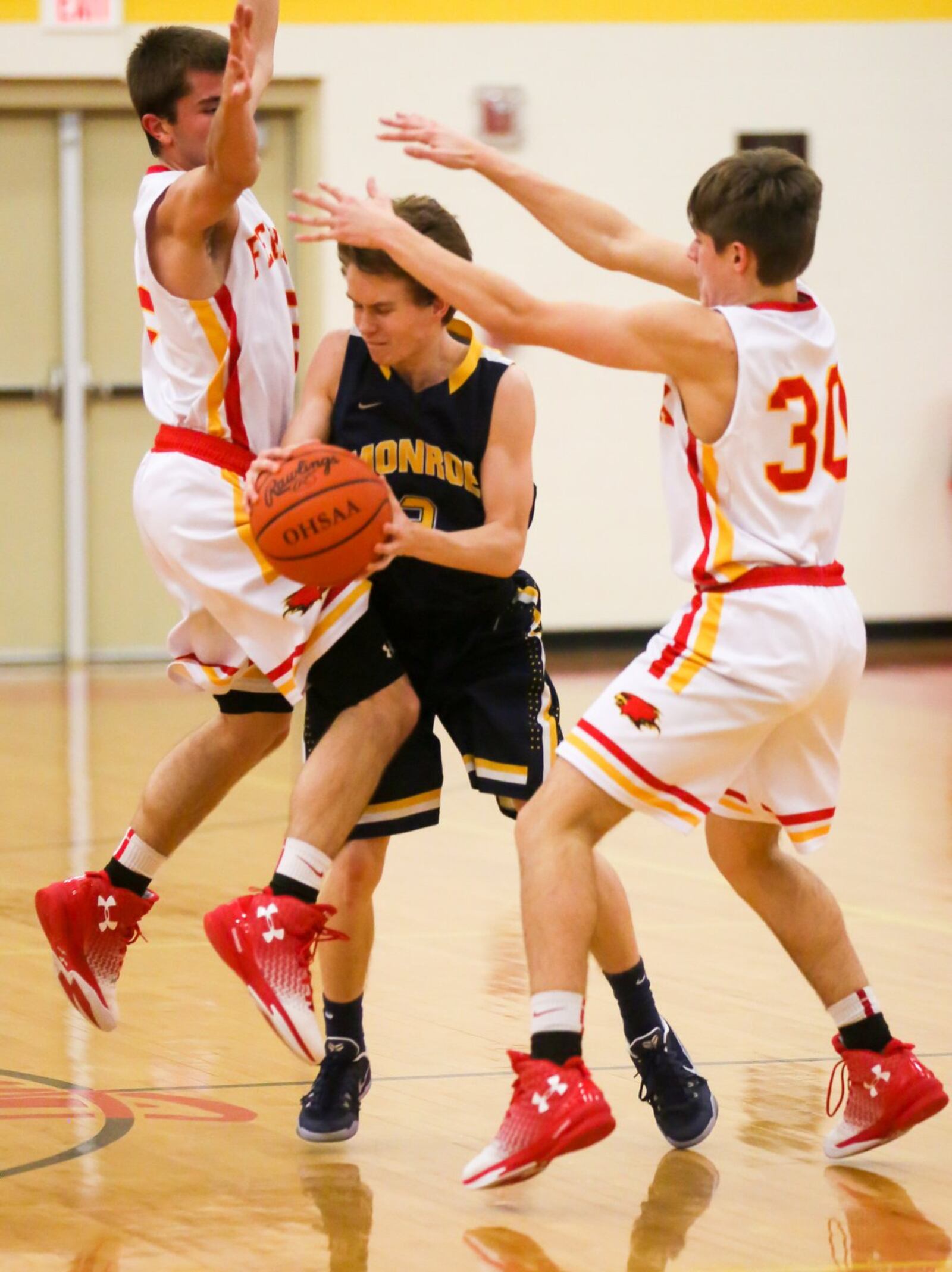 Monroe guard Devon Hubbard (3) cuts between Fenwick defenders Paul Blodgett (left) and John Engelmeier (30) during Tuesday night’s contest at Fenwick. GREG LYNCH/STAFF
