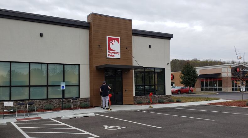 A patient talks to a security guard outside Strawberry Fields, one of two medical marijuana dispensaries in Butler County. The business at 300 N. Main St. in Monroe officially opened Friday, Oct. 25, 2019, two days after its soft opening. ERIC SCHWARTZBERG/STAFF