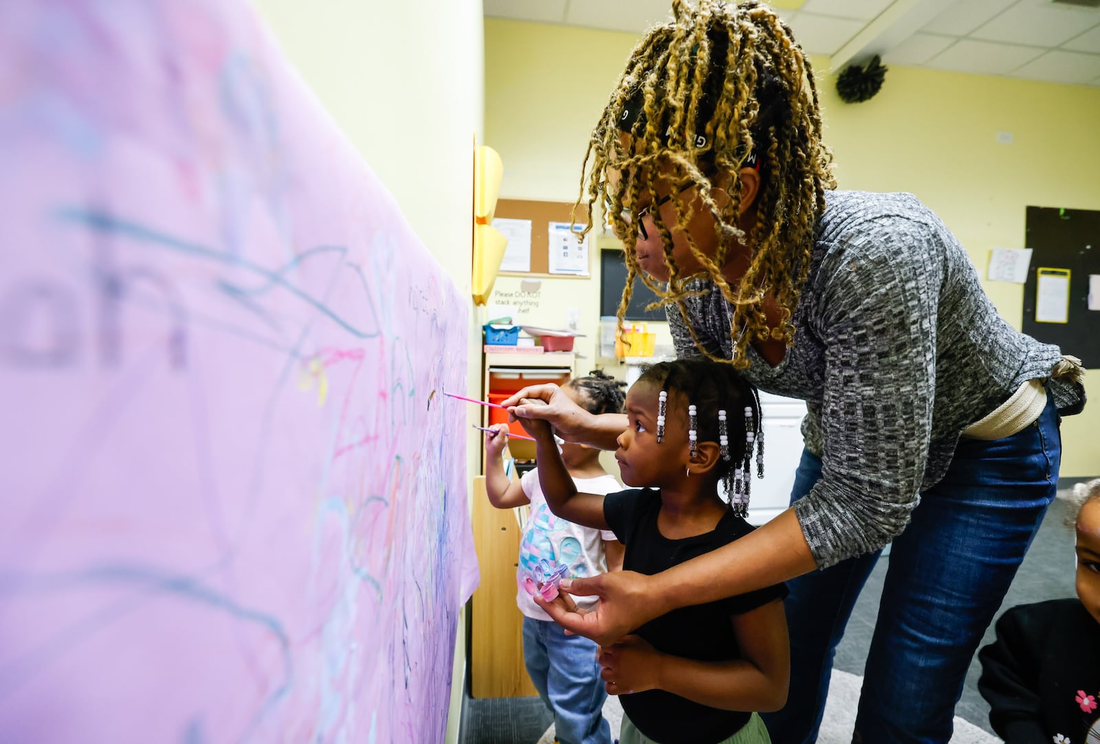 Monica Mills tends to toddlers at Loving Babies N' Tots childcare Thursday, March 19, 2026. Ohio’s recent changes to publicly funded child care reimbursements are putting added pressure on providers already operating on slim margins, including Loving Babies N' Tots owner Markida Jackson of Hamilton. Jackson opened the business four years ago at 3320 Tylersville Road in Fairfield Twp. NICK GRAHAM/STAFF