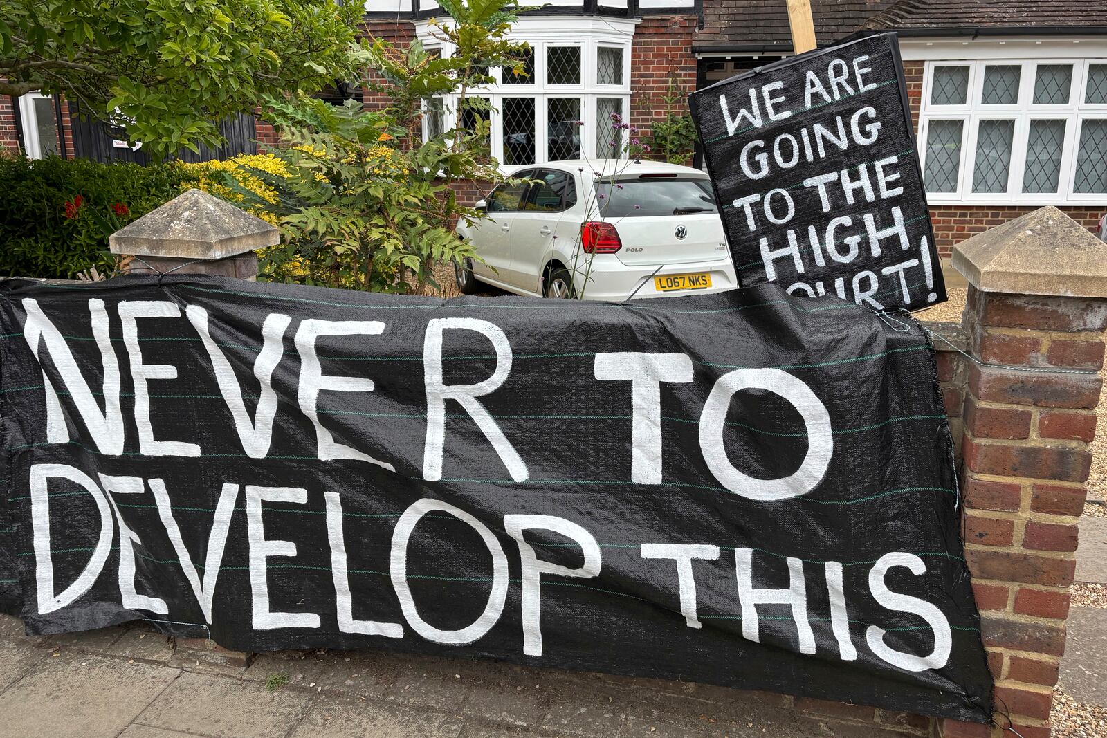 A banner opposed to Wimbledon's major expansion plan is placed outside a house leading to the All England Club where the Wimbledon Tennis Championships take place in London, Saturday, July 5, 2025. (AP Photo/Tony Hicks)