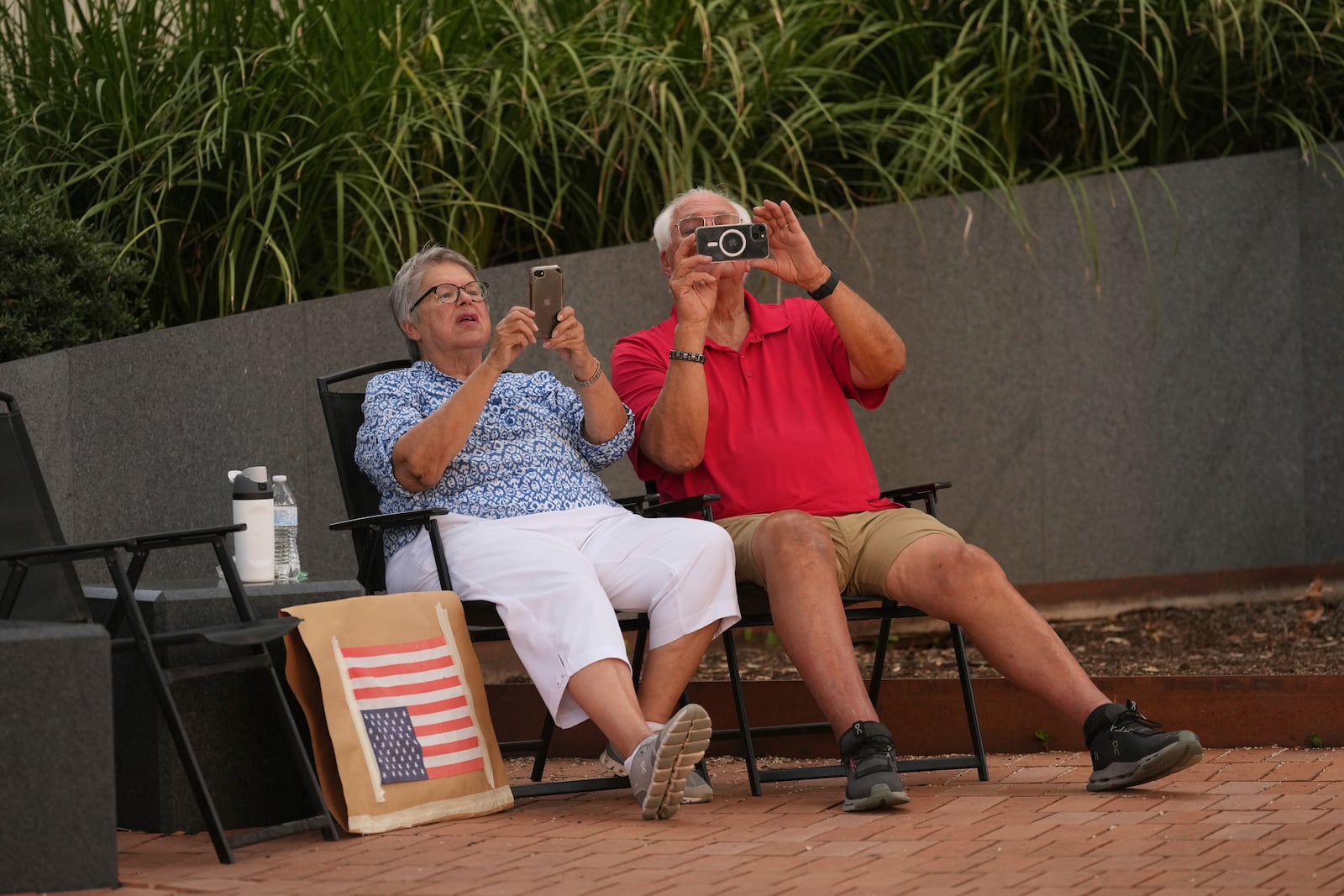 Visitors record by their phones as anti ICE protesters march in downtown San Antonio, Wednesday, June 11, 2025. (AP Photo/Eric Gay)