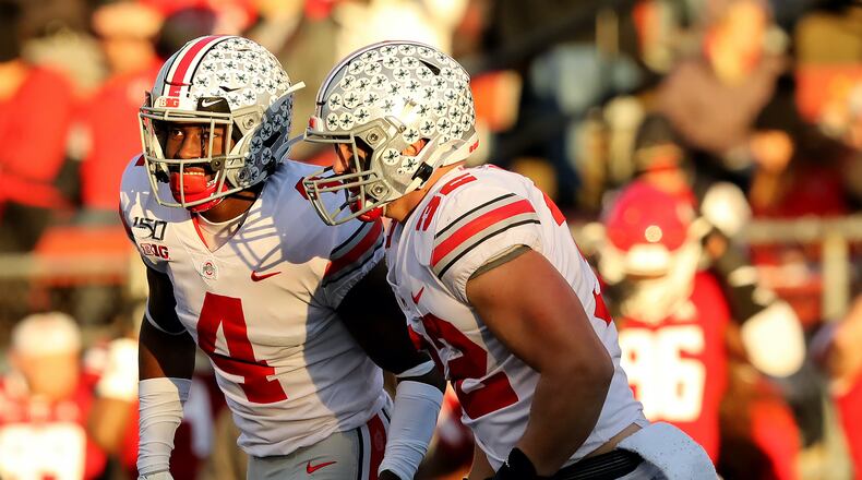 PISCATAWAY, NEW JERSEY - NOVEMBER 16: Jordan Fuller #4 and Tuf Borland #32 of the Ohio State Buckeyes celebrate a turnover in the first half against the Rutgers Scarlet Knights at SHI Stadium on November 16, 2019 in Piscataway, New Jersey.The Ohio State Buckeyes defeated the Rutgers Scarlet Knights 56-21. (Photo by Elsa/Getty Images)