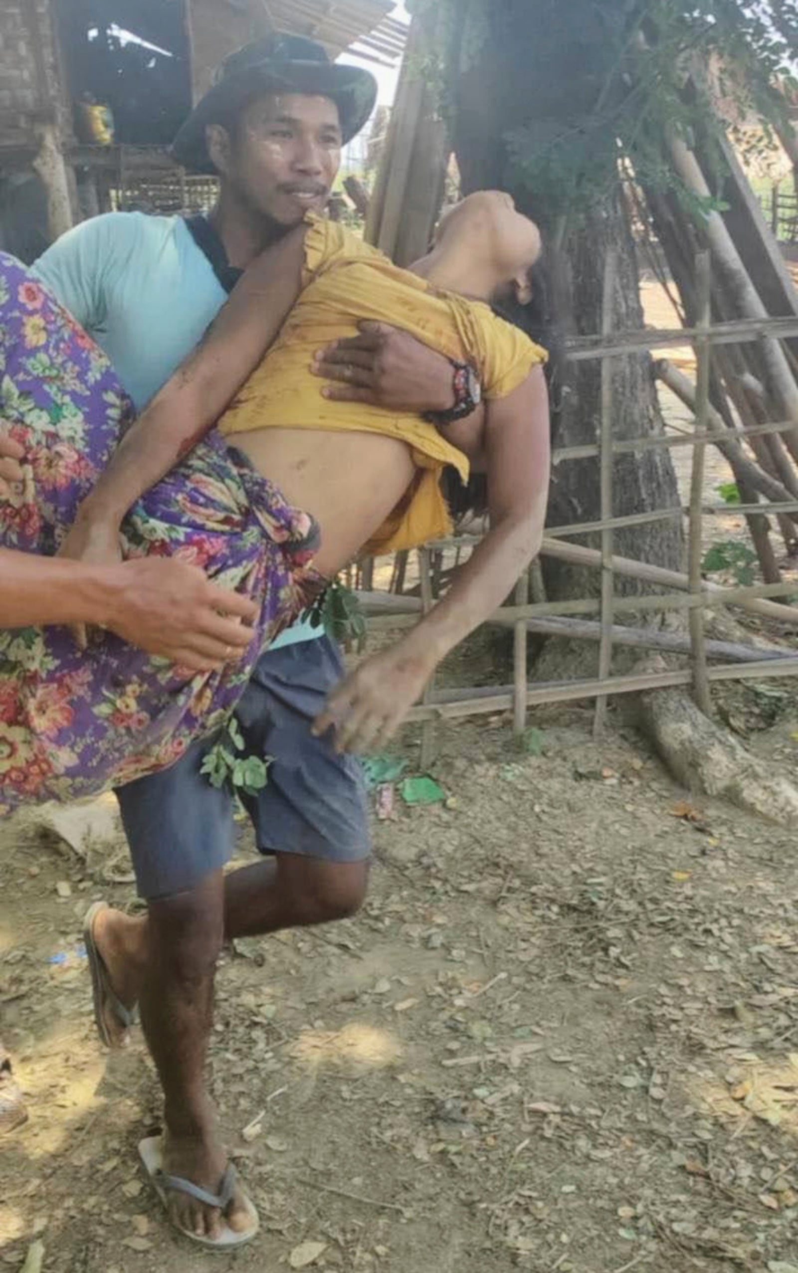 This photo from the private relief group Free Burma Rangers shows a man carrying the body of his 29-year-old wife after she was killed in an aerial bombing believed to have been carried out by Myanmar's military government on Hsaw Hti township's KyonKyang village in Karen state on Friday, April 25, 2025. (Free Burma Rangers via AP)