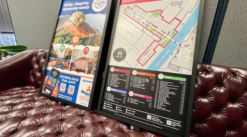Over the next couple of months, the city of Hamilton will install pedestrian wayfinder signs in about two dozen locations in the city’s urban core. The signs will have three sides to show various amenities including distances to those amenities, around the urban core. Pictured are what will be on two of the three sides. MICHAEL D. PITMAN/STAFF