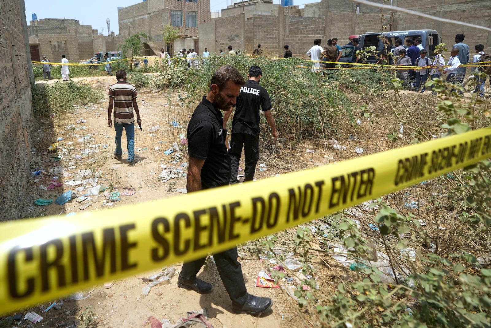 Pakistani investigators examine at a cordoned off site, where Pakistan's air defense system shot down a suspected Indian drone, in Karachi, Pakistan, Thursday, May 8, 2025. (AP Photo/Fareed Khan)