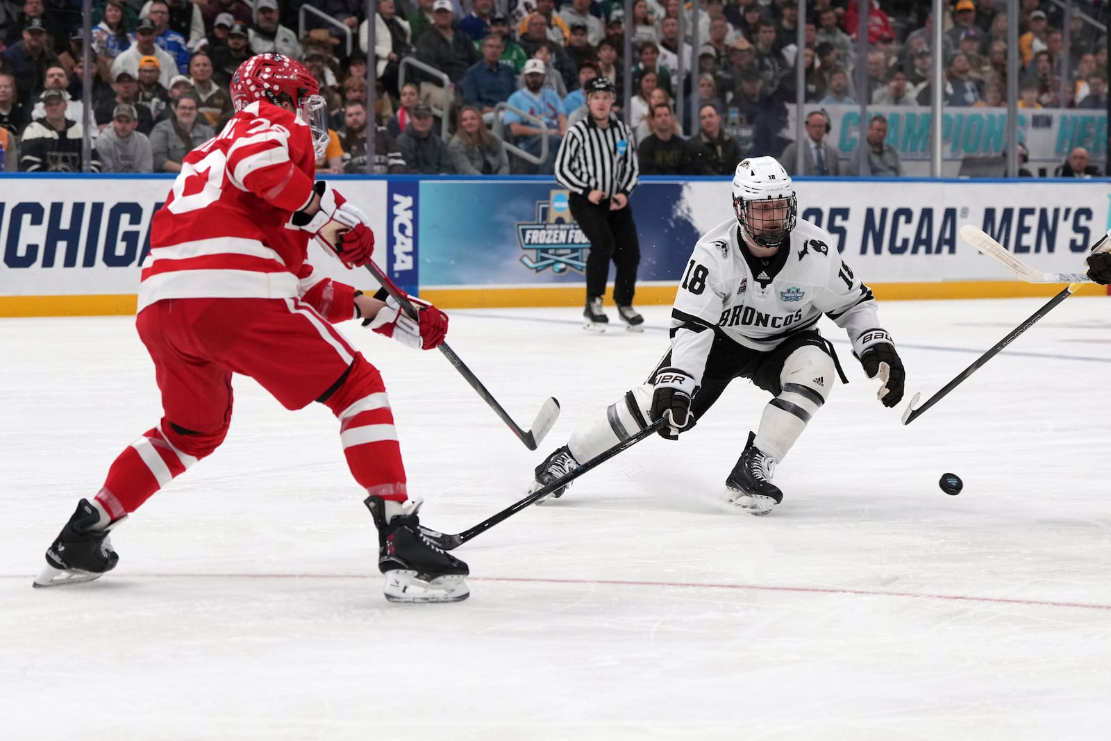 Boston University's Sascha Boumedienne, left, pass around Western Michigan's Wyatt Schingoethe (18) during the first period in the championship game of the NCAA Frozen Four men's college hockey tournament, Saturday, April 12, 2025, in St. Louis (AP Photo/Jeff Roberson)