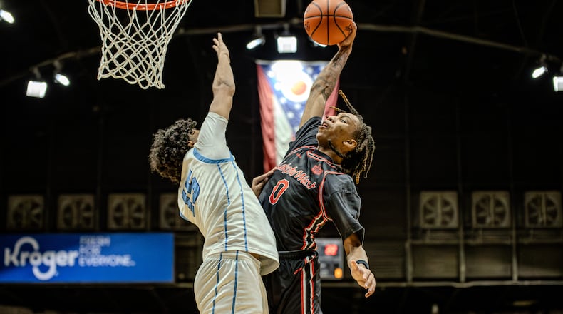 Lakota West junior Bryce Curry leaps for a dunk while being defended by Olentagy Berlin's Brayden Green during a Division I regional semifinal game on Thursday, March 12, 2026 at the Ohio Expo Center's Taft Coliseum. MICHAEL COOPER / STAFF