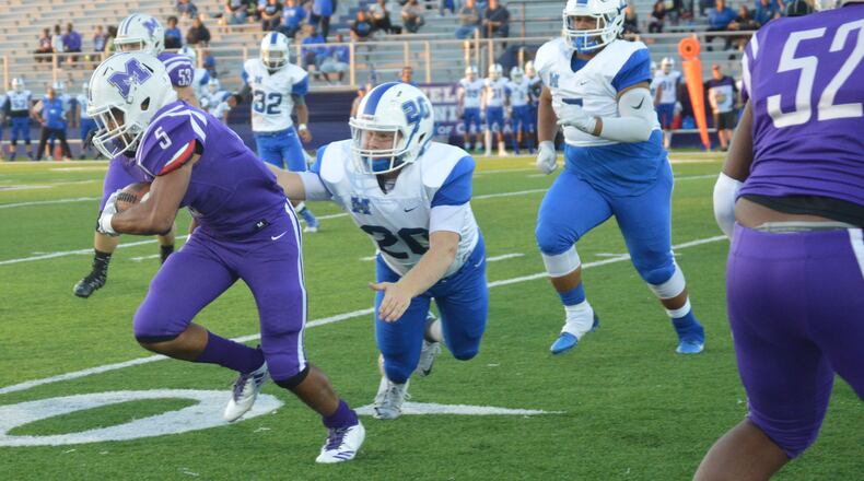 Hamilton’s Elijah Spradling (20) gets a hand on Middletown running back Diondre Cooper (5) during a game at Barnitz Stadium in Middletown on Sept. 29, 2017. The visiting Big Blue won 47-26. CONTRIBUTED PHOTO BY MARITZA MCKINNEY