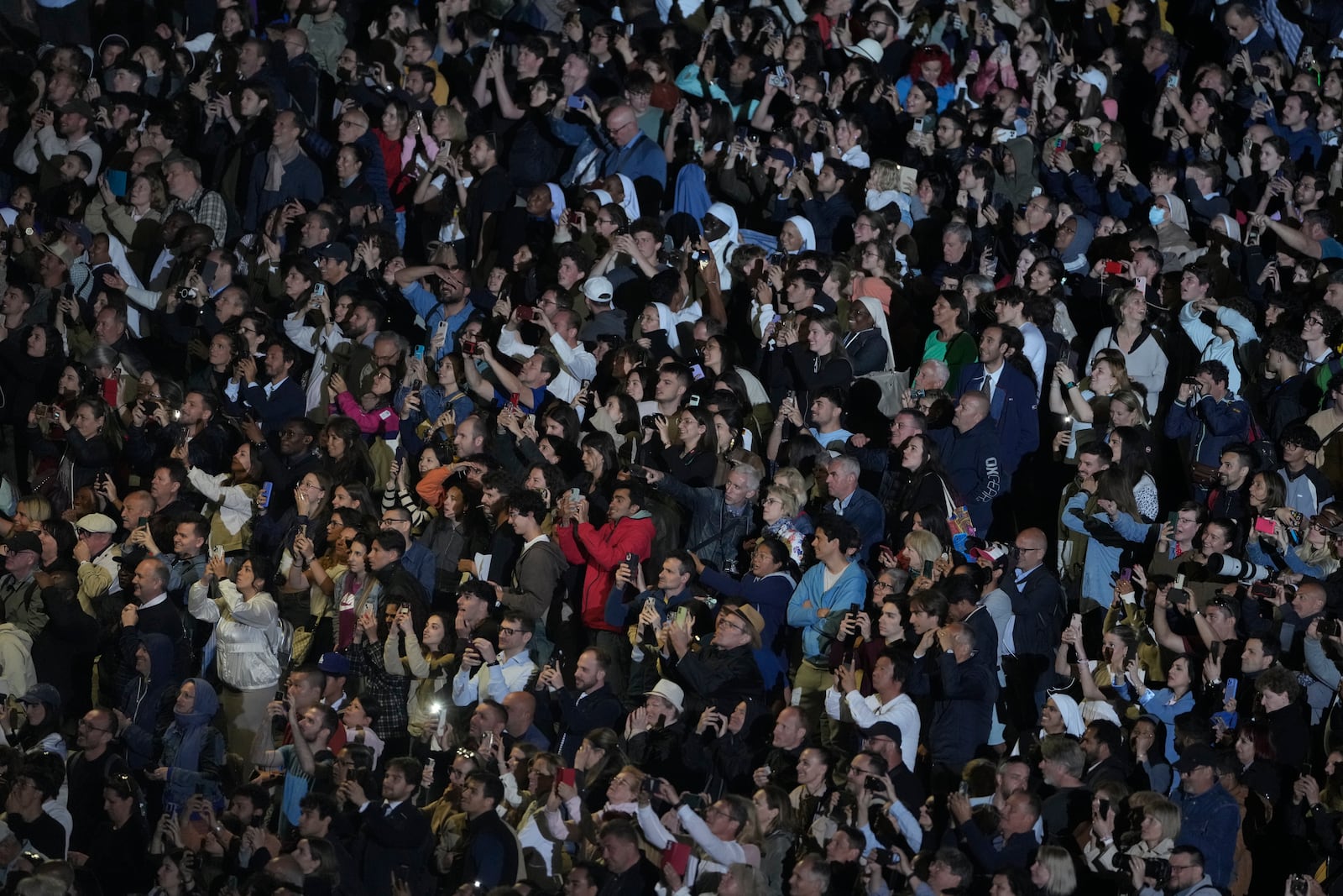 People react in St. Peter's Square at the Vatican after black smoke billowed from the chimney of the Sistine Chapel, where 133 cardinals are gathering on the first day of the conclave, indicating that a successor of late Pope Francis was not elected, Wednesday, May 7, 2025. (AP Photo/Markus Schreiber)