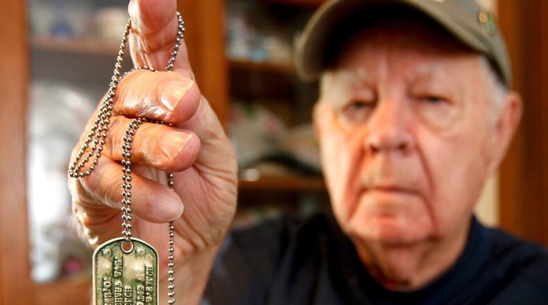 World War II United States Army veteran Bill Wilch with the dog tags he wore when he stormed the beaches of Normandy with the 29th Ranger Battalion during the D-Day invasion in 1944. STAFF FILE/2014