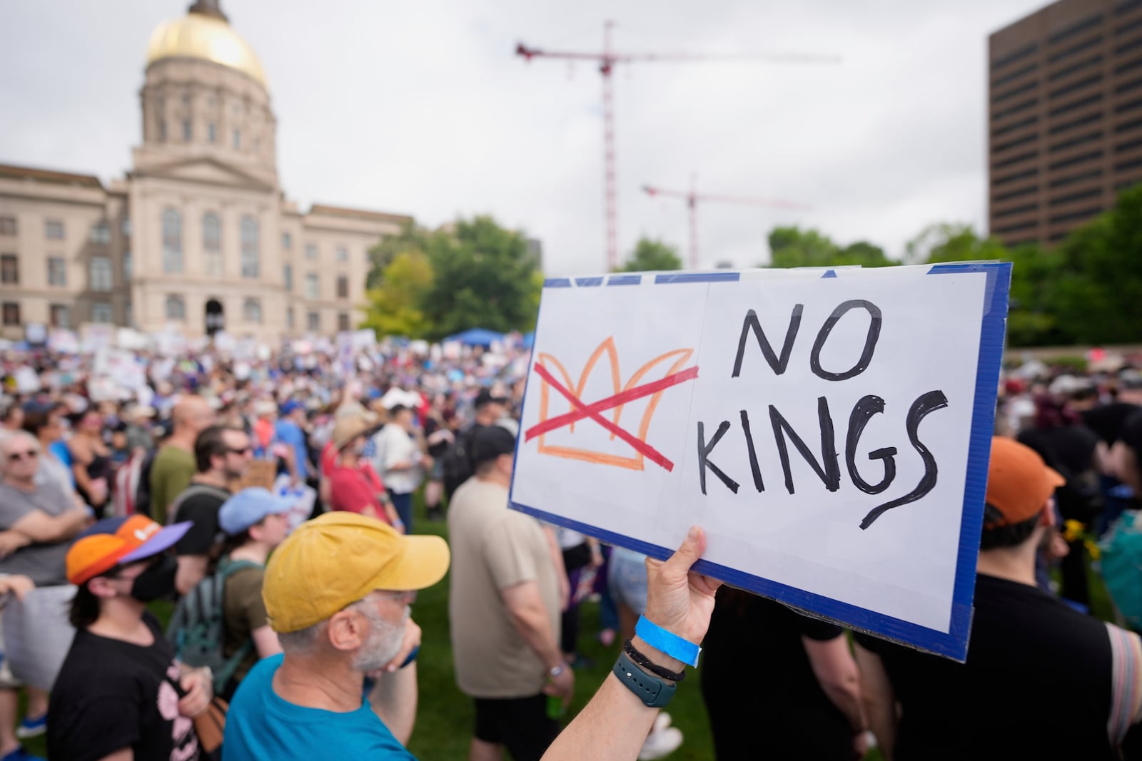 A demonstrator holds a sign during a "No Kings" protest, Saturday, June 14, 2025, in Atlanta. (AP Photo/Mike Stewart)