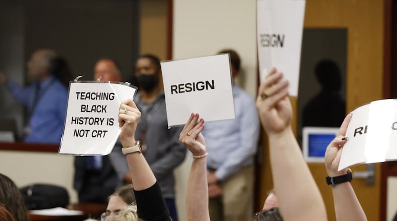 Attendees hold up signs during the Lakota Board of Education meeting that lasted over three hours in May 2022. Lakota’s school board is considering a new public speaking policy for its meetings as the latest in a series of procedural changes in response to periodic contentiousness during its meetings. NICK GRAHAM/STAFF