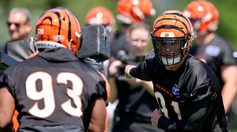 Cincinnati Bengals defensive end Trey Hendrickson (91) performs a drill against defensive end Jeff Gunter (93) during a NFL football practice, Tuesday, May 28, 2024, in Cincinnati. (AP Photo/Jeff Dean)