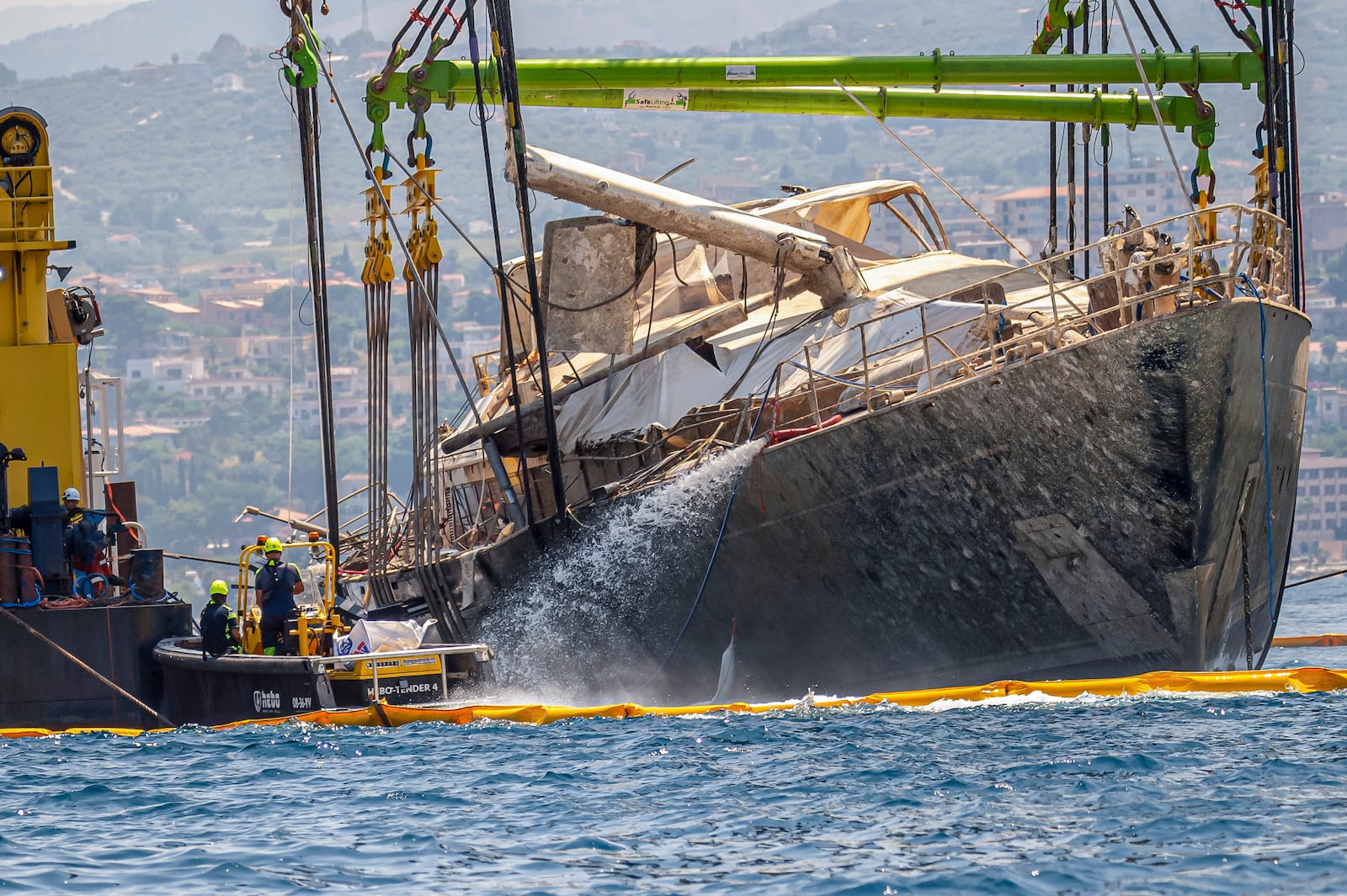 The hull of the superyacht Bayesian, which sank near Palermo, Sicily, on August 19, 2024, is pulled out of the sea off the village of Porticello and dewatered, Saturday, June 21, 2025. (AP Photo/Salvatore Cavalli)