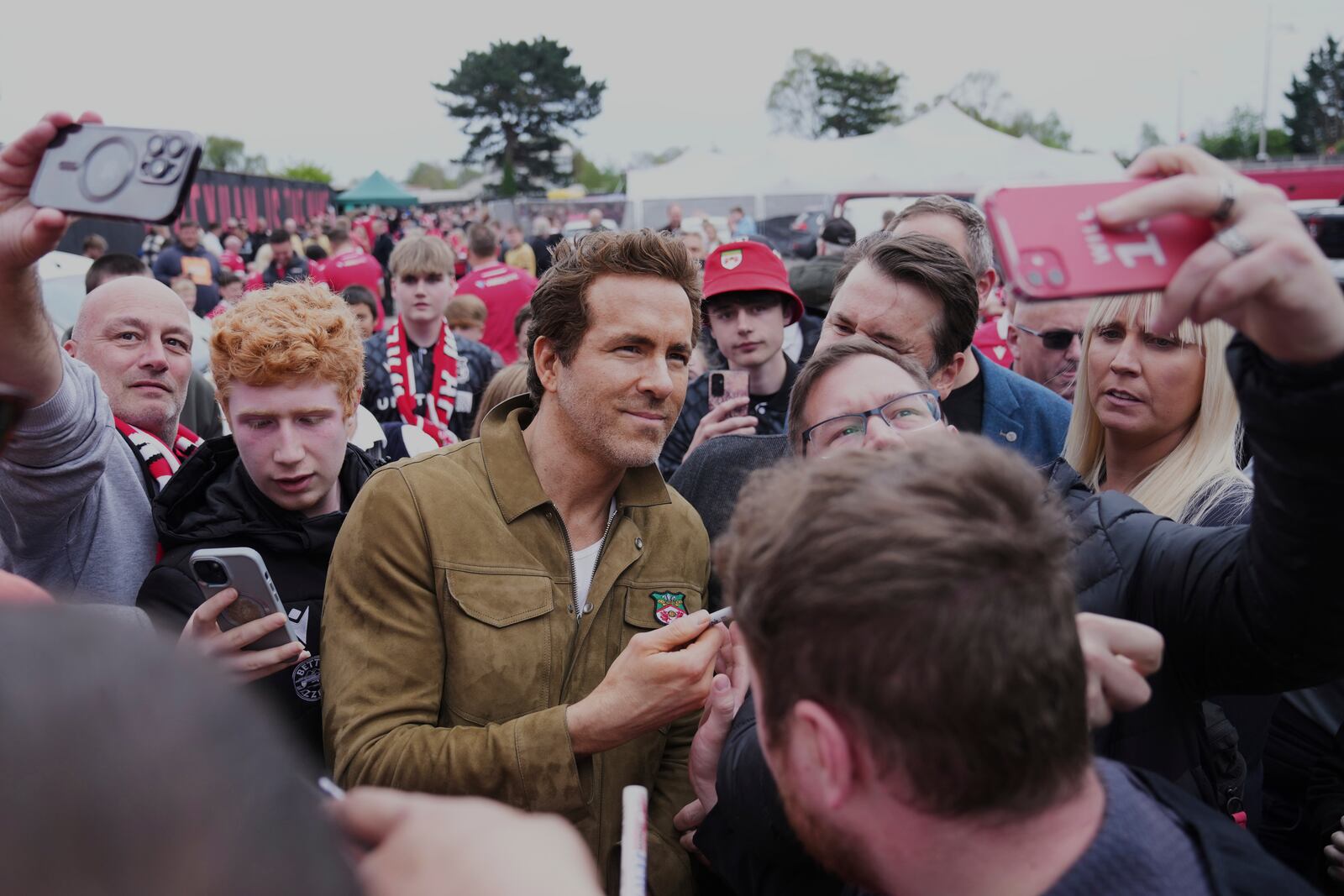 Wrexham co-owner Ryan Reynolds, center, arrives at the Racecourse ground stadium prior to the English League One soccer match between Wrexham and Charlton Athletic in Wrexham, Wales, Saturday, April 26, 2025. (AP Photo/Jon Super)