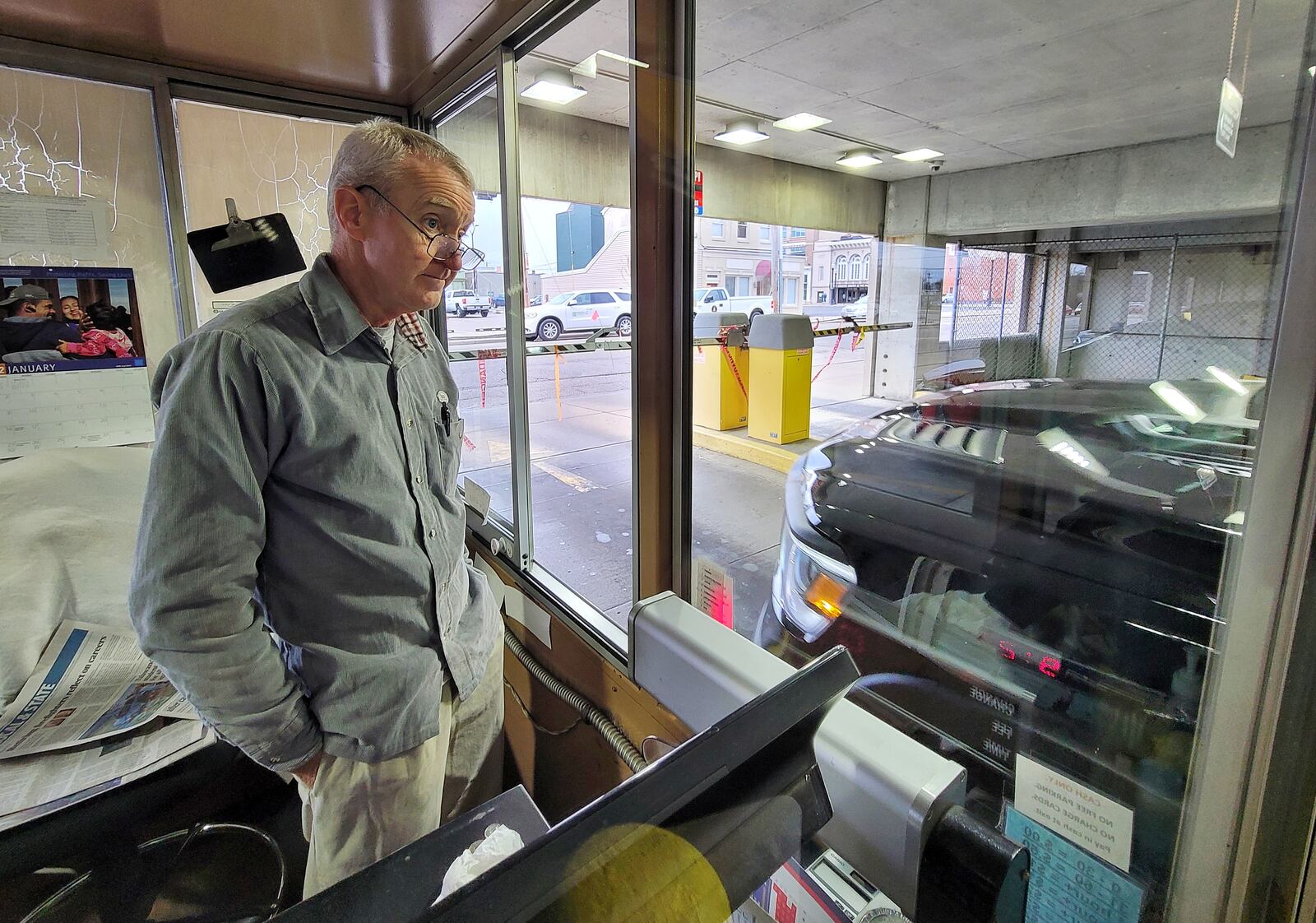 Kevin Johnston works the exit gate at the Butler County Government Services Center parking garage Thursday, Jan. 6, 2022 in Hamilton. Butler County Commissioners have awarded a $200,000 contract to fully automate the garage. NICK GRAHAM / STAFF