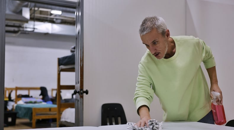 Robert McWhorter cleans tables at Serve City homeless shelter Wednesday, Jan. 24, 2024 on East Ave. in Hamilton. Shelters in the area saw an increase in attendance due to extreme cold over the last weeks. NICK GRAHAM/STAFF