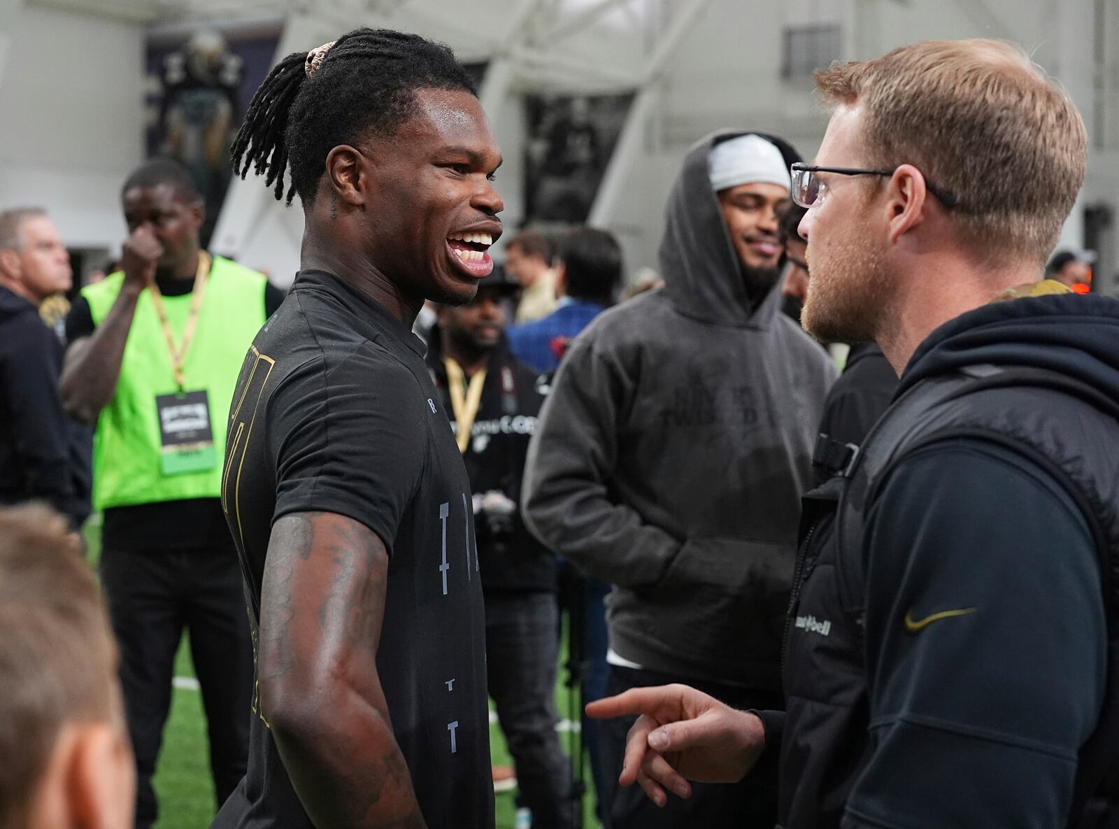 Colorado wide receiver Travis Hunter, left, greets a scout during the team's NFL football pro day Friday, April 4, 2025, in Boulder, Colo. (AP Photo/David Zalubowski)