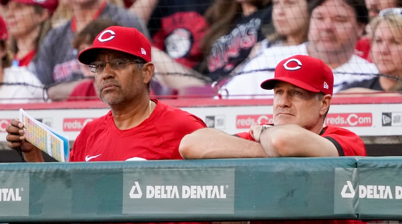 Cincinnati Reds manager David Bell, right, stands in the dugout with bench coach Freddie Benavides during the sixth inning of a baseball game against the St. Louis Cardinals Saturday, April 23, 2022, in Cincinnati. (AP Photo/Jeff Dean)