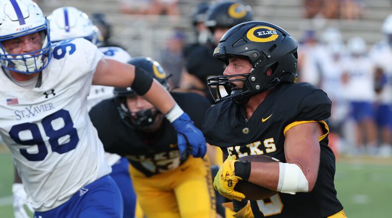 Centerville's Andrew Erwin carries the ball into the St. Xavier secondary during Friday's game. BILL LACKEY/STAFF