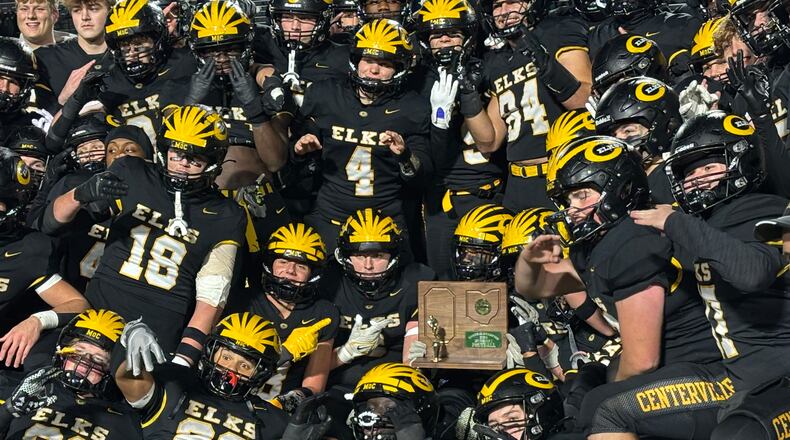 Trophy Centerville football players pose with OHSAA football regional championship trophy after beating Wayne at Welcome Stadium on Friday night, Nov. 22, 2024.